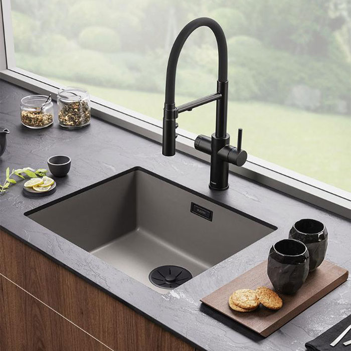 Moderne køkken i skandinavisk stil, med grå køkkenvask og et højt, semi-prof køkkenarmatur.